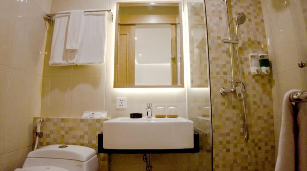 e bagno con lavandino, servizi igienici e doccia. di UNUMA HOTEL a Giacarta