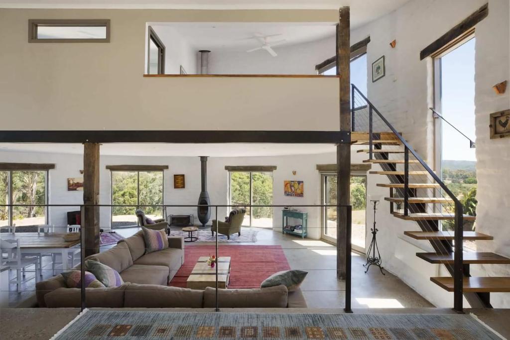 赫本溫泉的住宿－Lithia Guest House - Daylesford Region，带沙发和楼梯的客厅