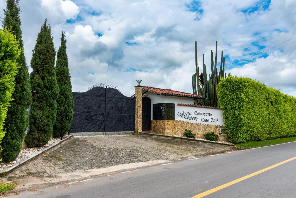 a building on the side of a road with trees at Hotel Campestre Cafe Cafe in Montenegro