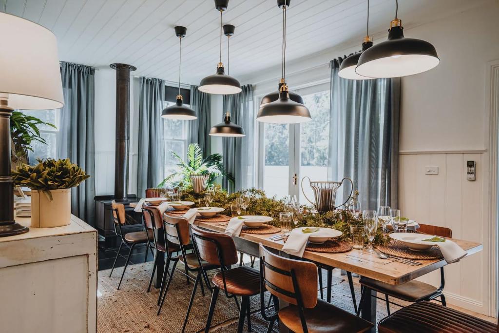 a dining room with a long table and chairs at The Gums - Daylesford Region in Korweinguboora