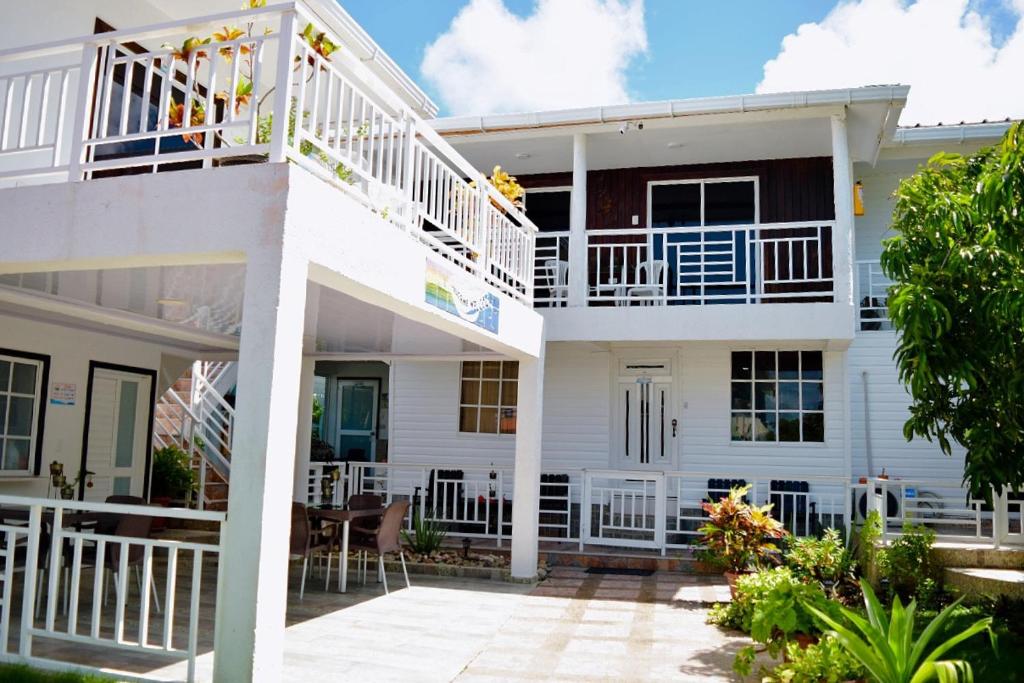 a white house with a balcony and a patio at Posada Jasmina Place in Providencia