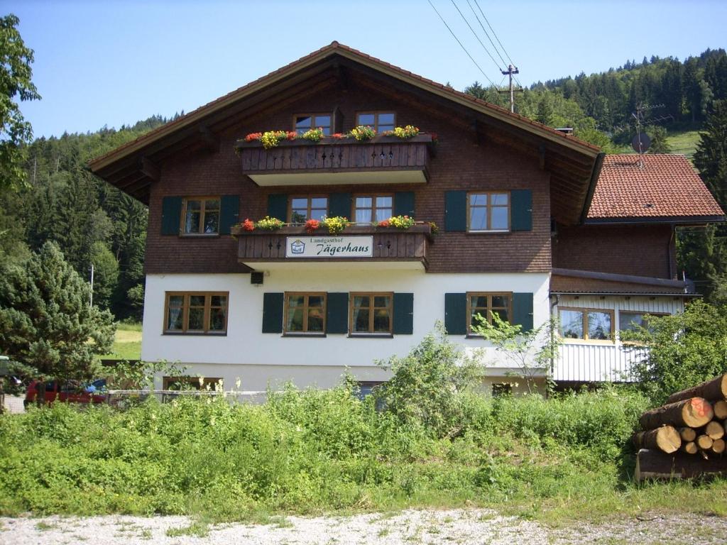 ein Haus mit einem Balkon mit Blumen darauf in der Unterkunft Landgasthof Jägerhaus in Immenstadt im Allgäu