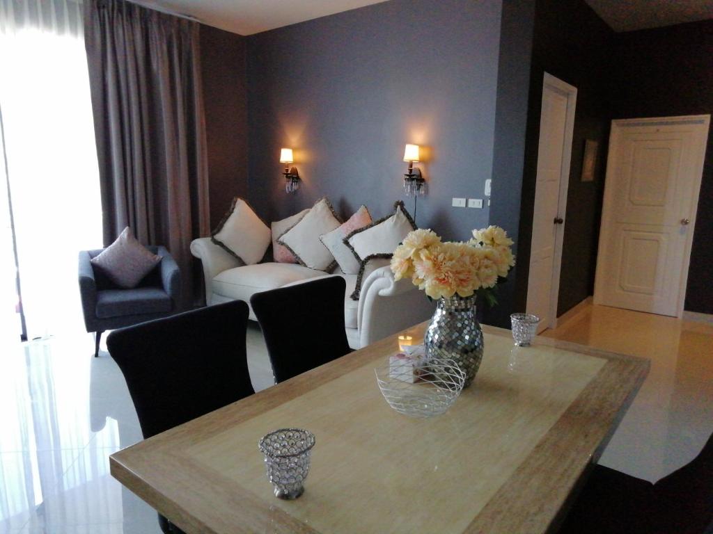 a living room with a vase of flowers on a table at Klong Muang Beach Apartment in Klong Muang Beach