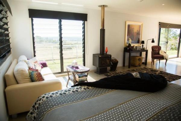 a bedroom with a bed and a living room with a couch at Deshons Country Retreat in Kingaroy