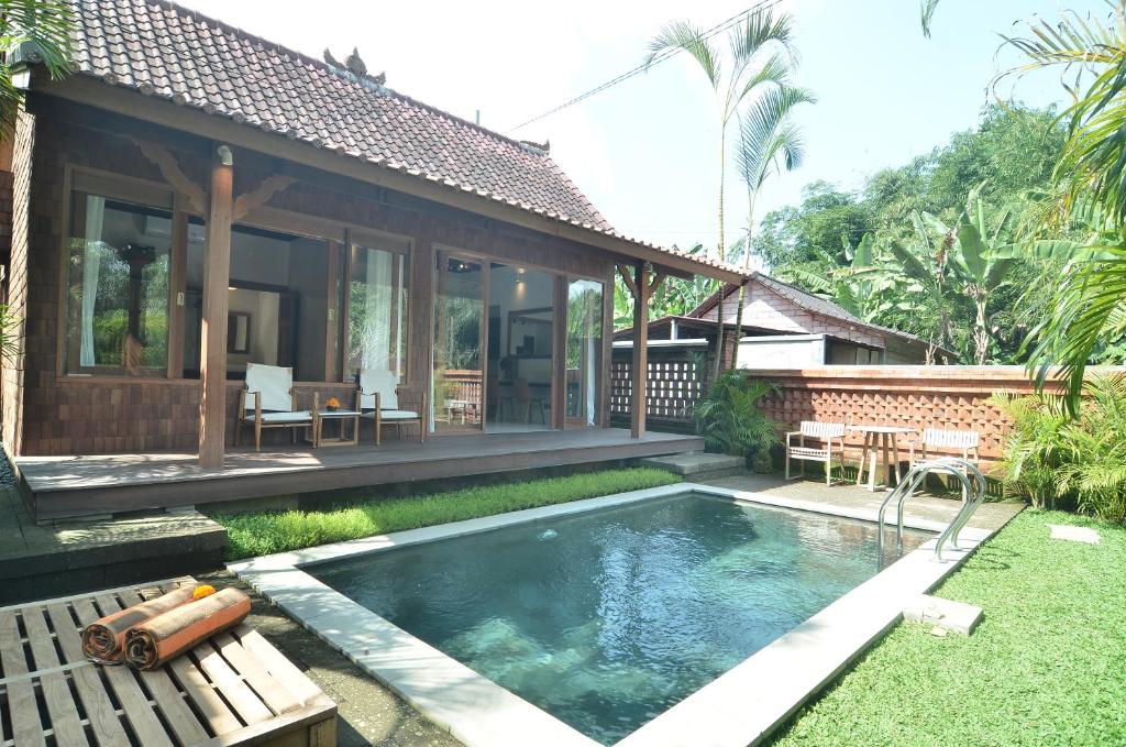 een huis met een zwembad ervoor bij Kubu Manis Villa in Ubud