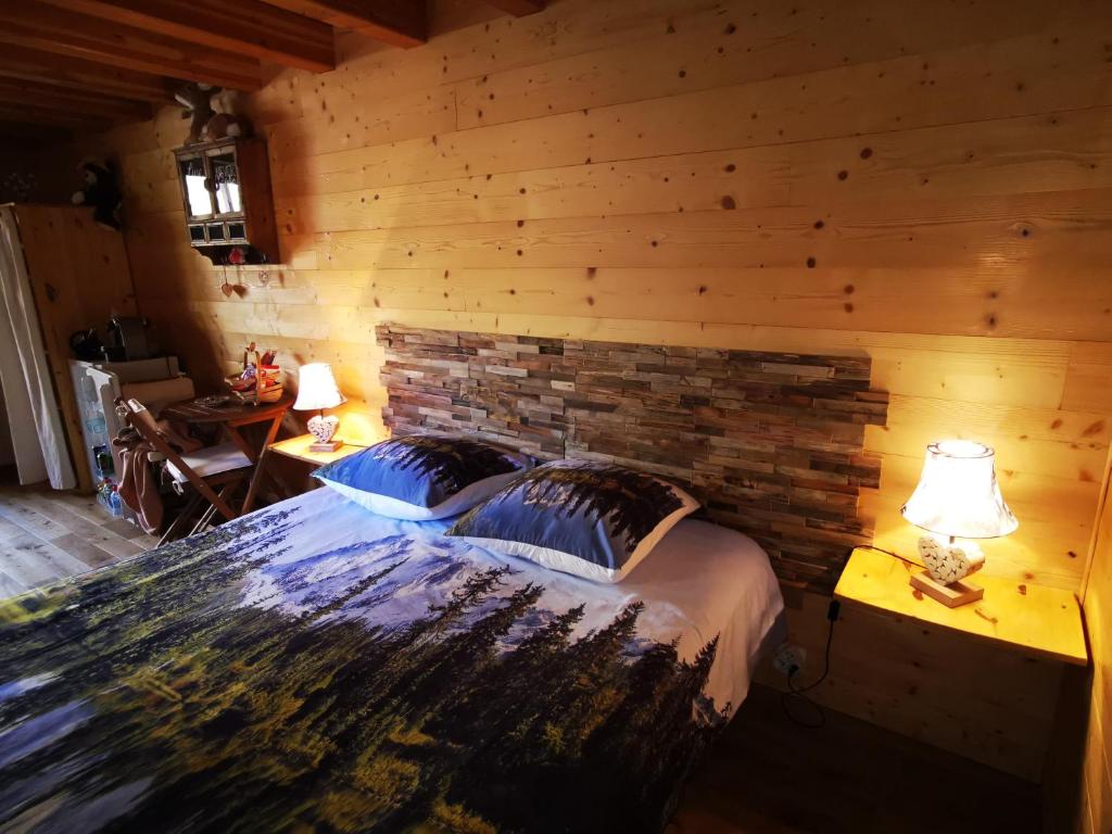 a bedroom with a brick wall and a bed with two lamps at Les marmottes d Estenc in Estenc
