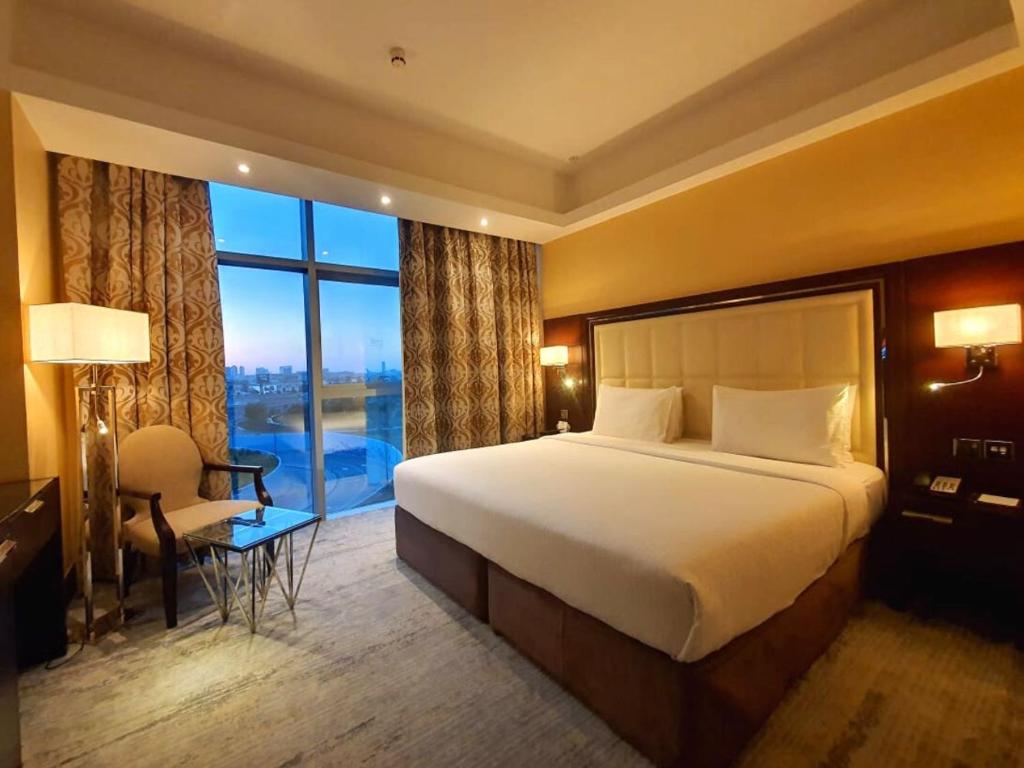 a hotel room with a bed and a large window at Copthorne Hotel Dubai in Dubai