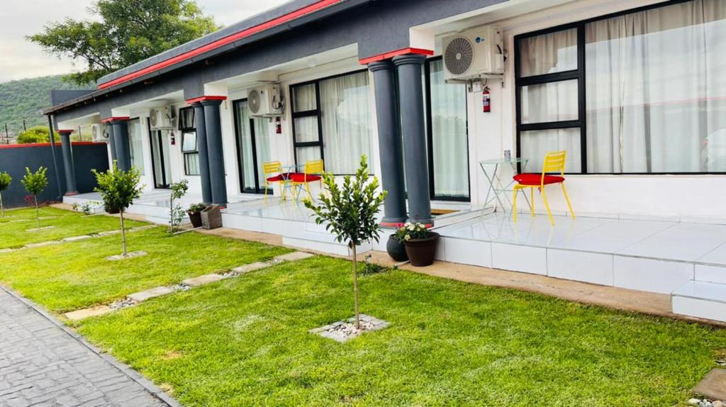 a building with chairs and tables on the grass at AB & AB Residence in Burgersfort