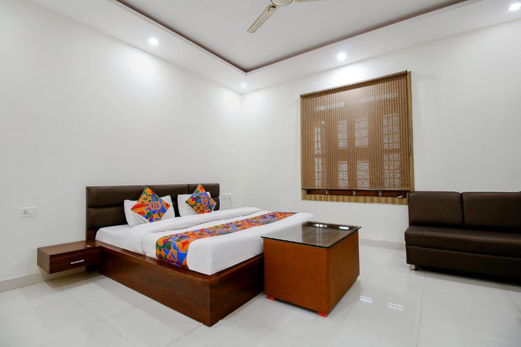 a bedroom with a bed and a couch in it at FabExpress Yuvan in Naiāpura