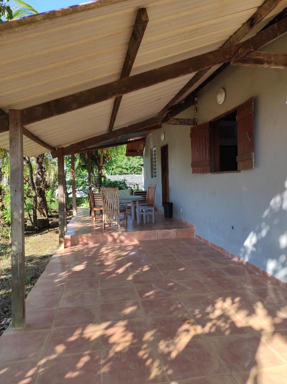 eine überdachte Terrasse mit einem Tisch und Stühlen in der Unterkunft Tikoté Chwit point 1 in Cayenne
