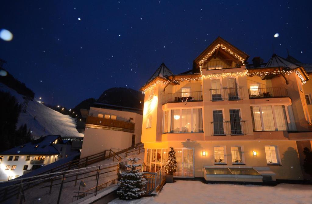 un gran edificio con luces de Navidad encendidas por la noche en Hotel Vista Allegra, en Ischgl