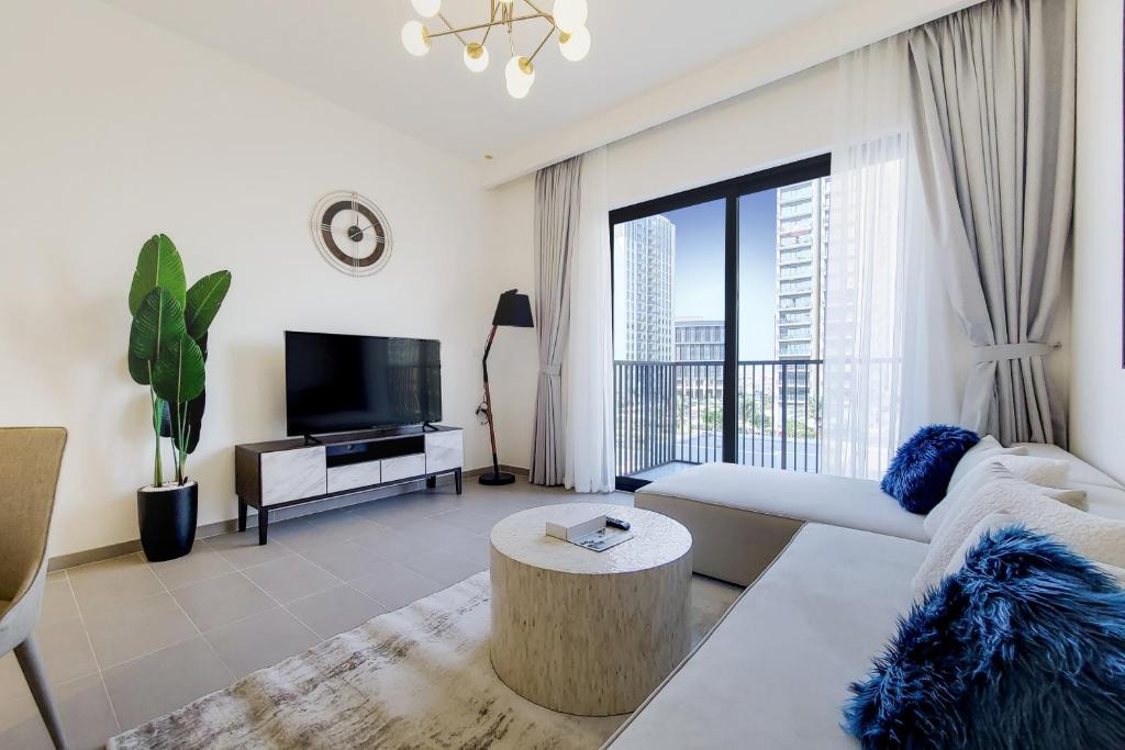 a living room with a couch and a tv at Primestay - Executive Residences in Dubai Hills Estate in Dubai
