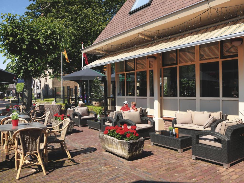 a patio with couches and tables and chairs at Hotel Kuik in Ruinen
