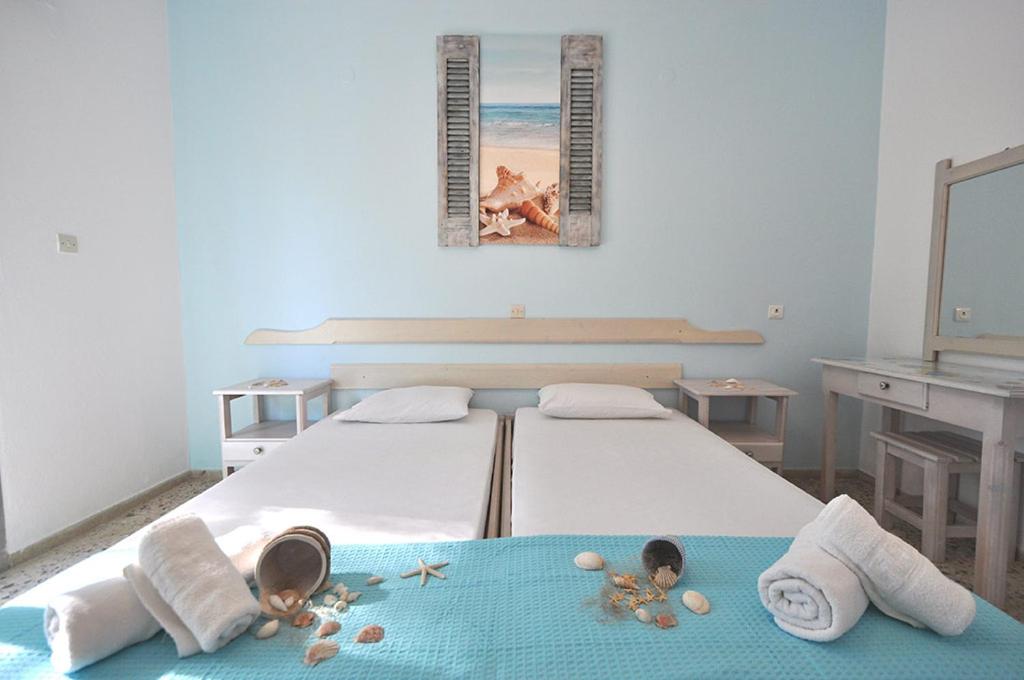 a bedroom with a bed with towels and a mirror at studio ermioni fresh 2 in Limenaria