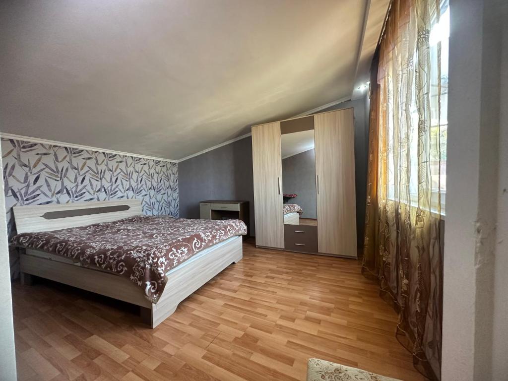 1 dormitorio con 1 cama y suelo de madera en Tamuna apartment, en Tiflis