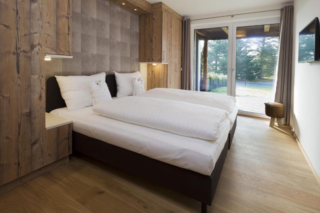 A bed or beds in a room at Ski & Golf Suites Zell am See by Alpin Rentals - incl Summercard