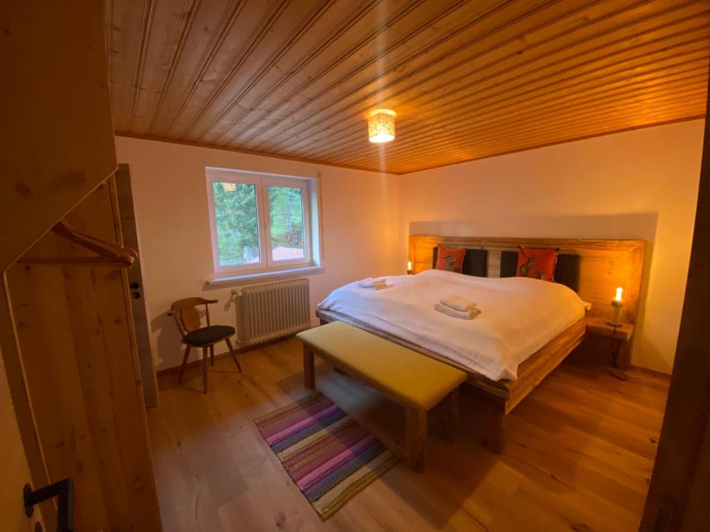 sypialnia z łóżkiem, biurkiem i oknem w obiekcie Gipfel Stuben w mieście Blaichach