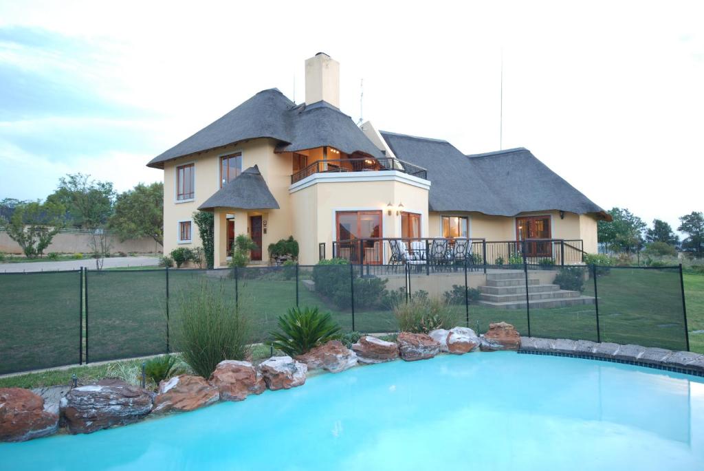 una casa con piscina di fronte a una casa di Hoopoe Haven Guest House a Chartwell