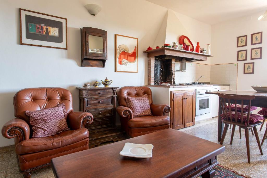 a living room with leather chairs and a table at Lidia - Agriturismo La Valentina in Talamone