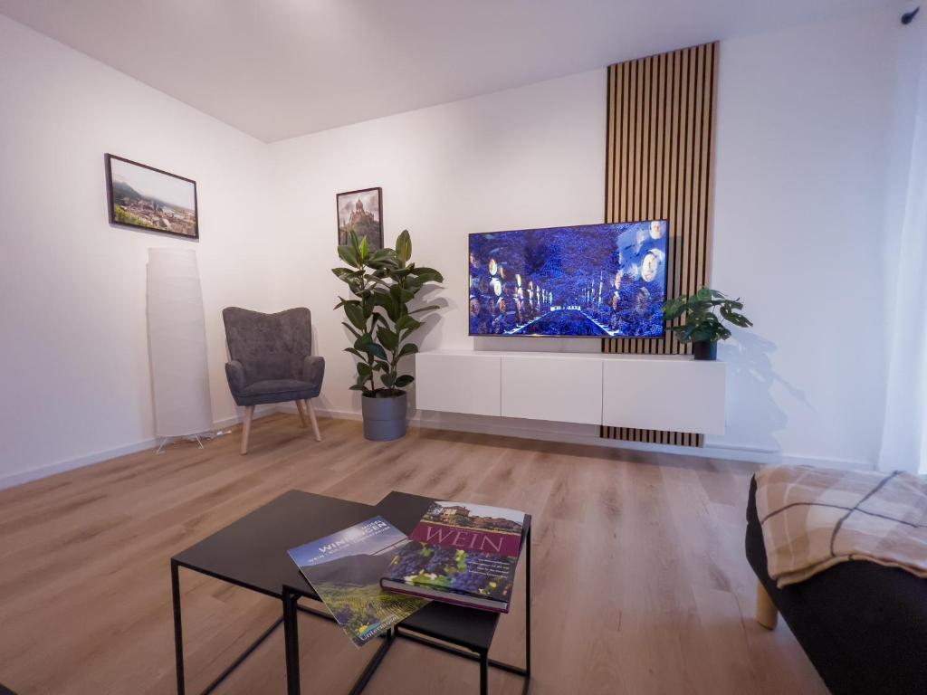 a living room with a table and a tv at 3-Zimmer Apartment 88 qm bis zu 8 Personen in Winningen