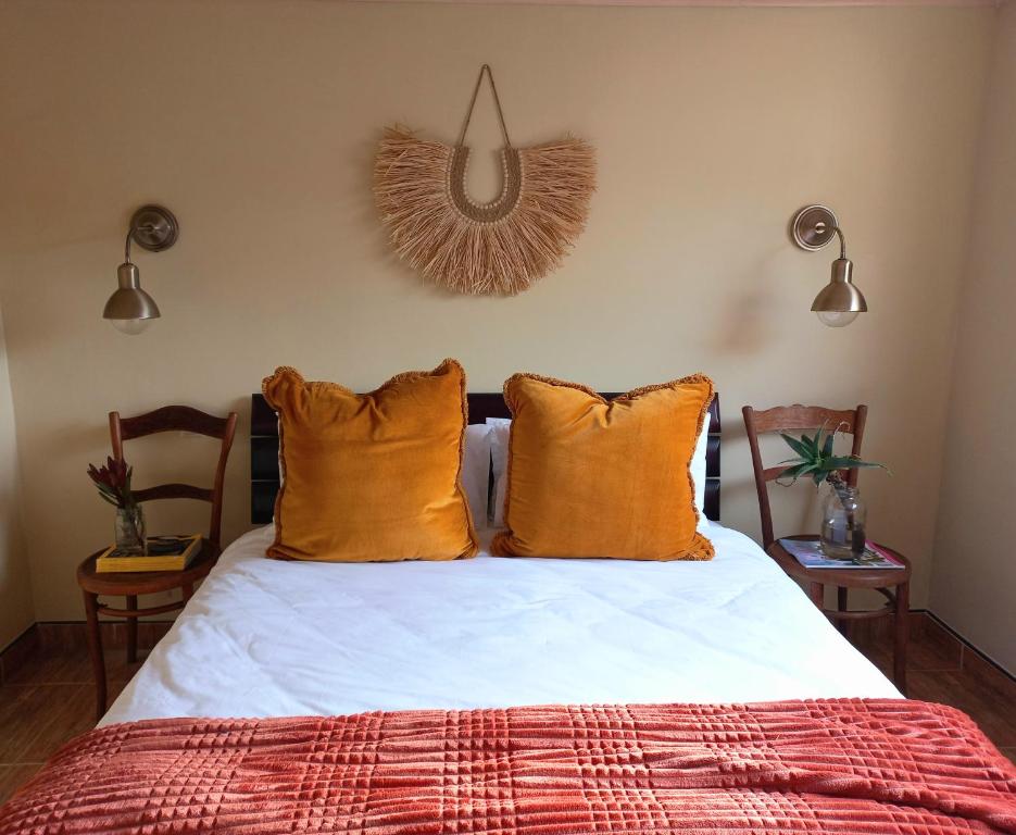 a bedroom with a bed with orange pillows at Essenhout Self-catering Accommodation in Grabouw