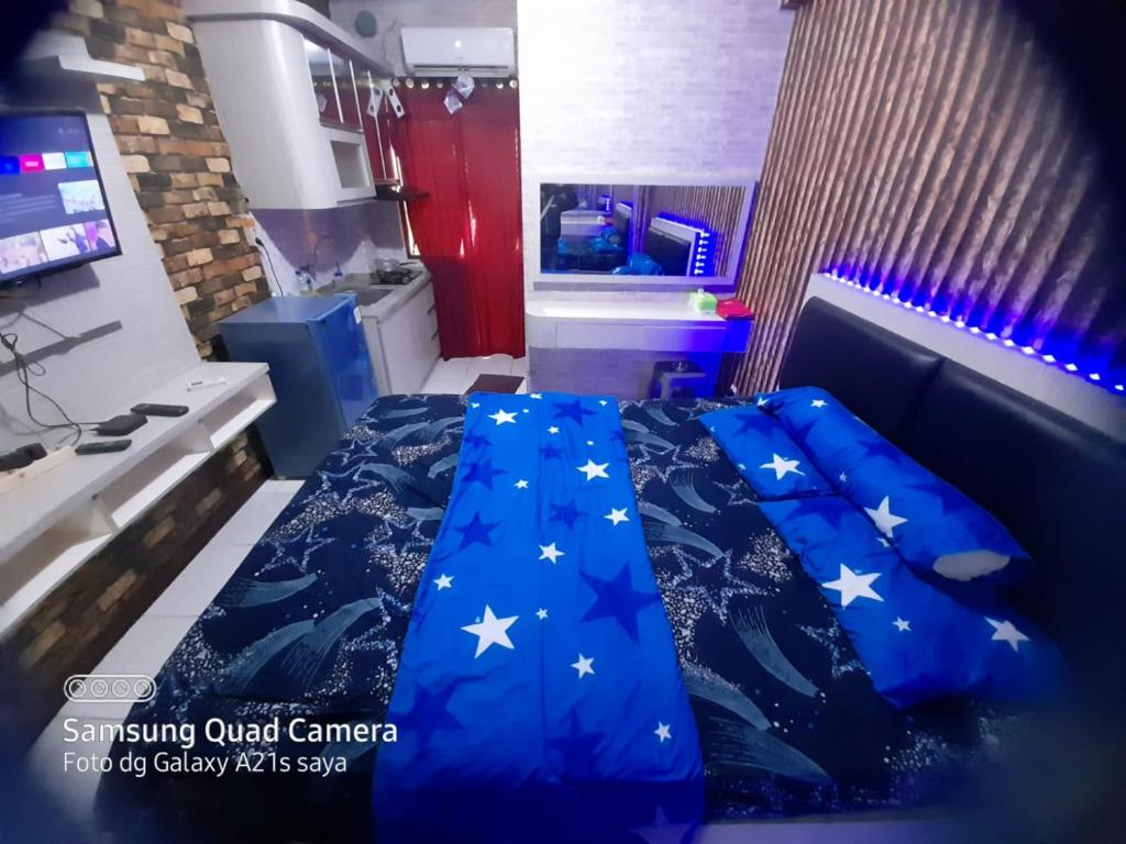 ein Schlafzimmer mit einem blauen Bett mit Sternen darauf in der Unterkunft Apartemen betos bydesiroom in Rawapanjang