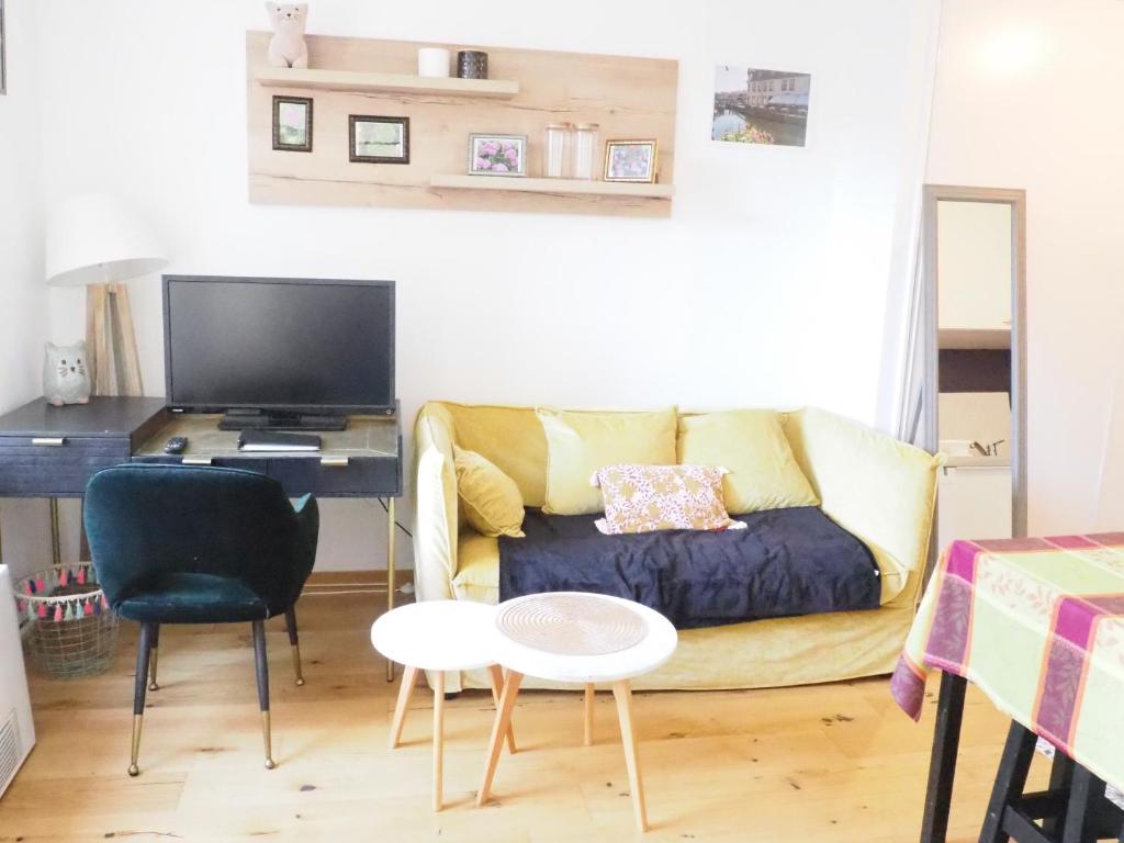 a living room with a couch and a desk at Les Halles : Studio Cosy et Moderne in Strasbourg