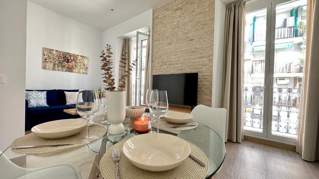 uma sala de jantar com uma mesa de vidro numa sala de estar em Mata Mua Suites em Sevilha