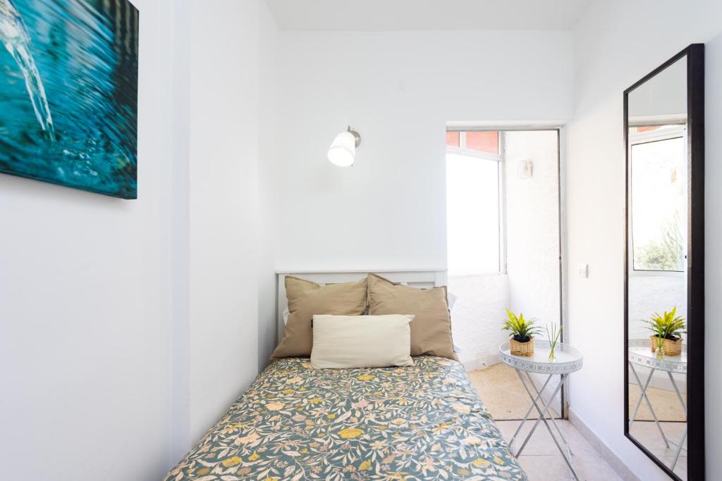 a bedroom with a bed in a room with a mirror at Home2Book Charming Duplex Tabaiba in Tabaiba