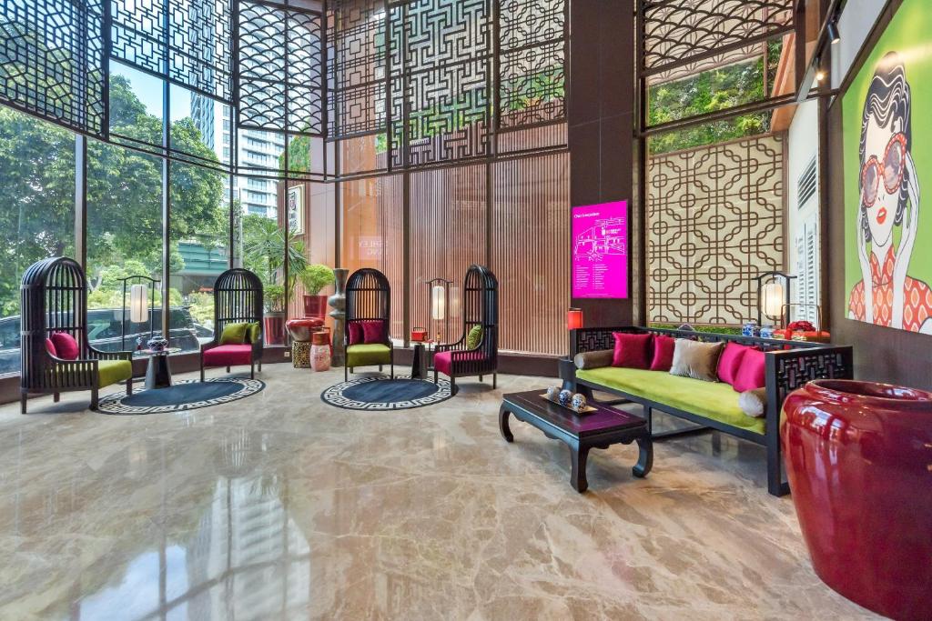 a lobby with a couch and chairs in a building at Ashley Tang Menteng Jakarta in Jakarta