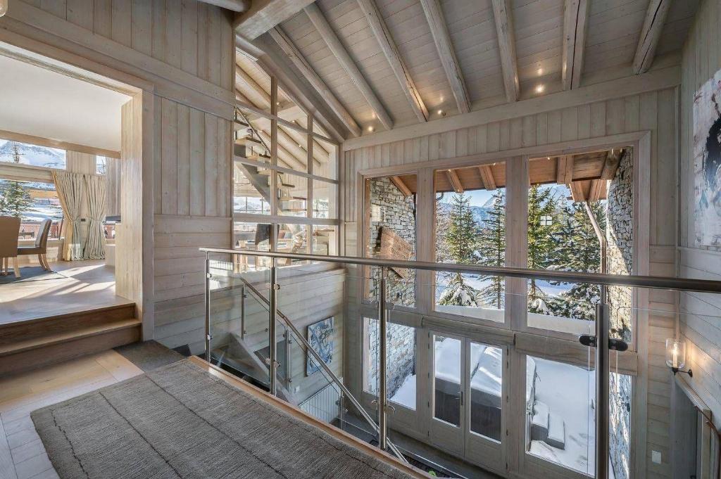 une maison avec une porte en verre et un balcon dans l'établissement Cisco-chalet-spa *tout*compris*, à Uvernet