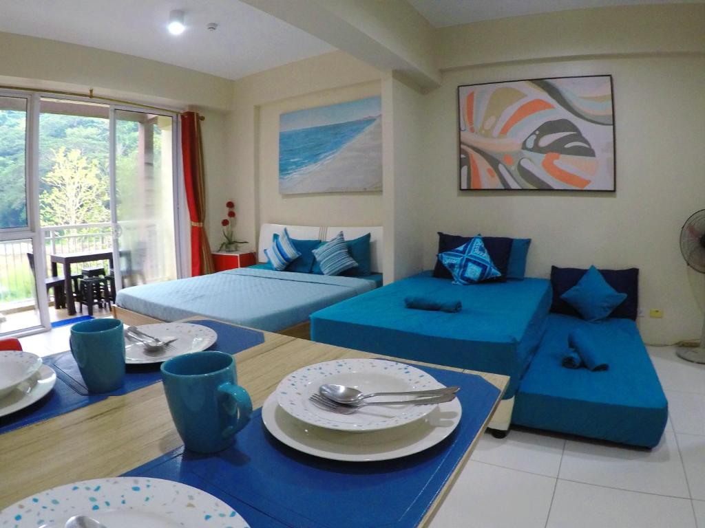 een woonkamer met 2 bedden en een tafel met borden bij Beach Getaway at Pico de Loro Hamilo Coast Nasugbu Batangas in Nasugbu