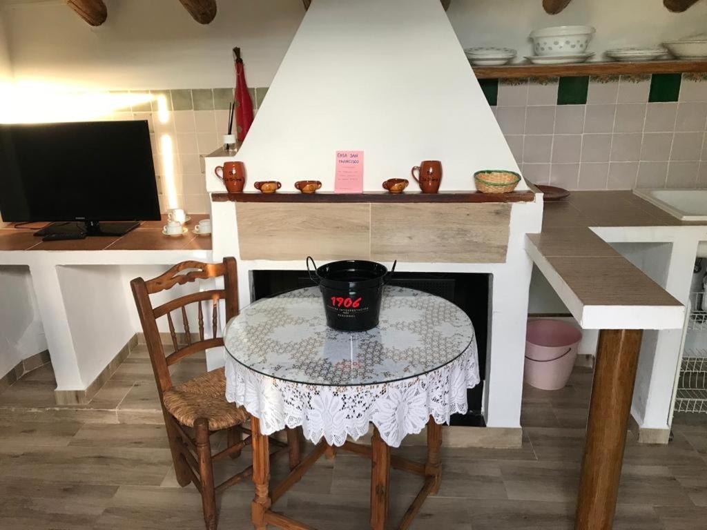 a table and chair in a kitchen with a stove at Vivienda el Olivar in Mogón