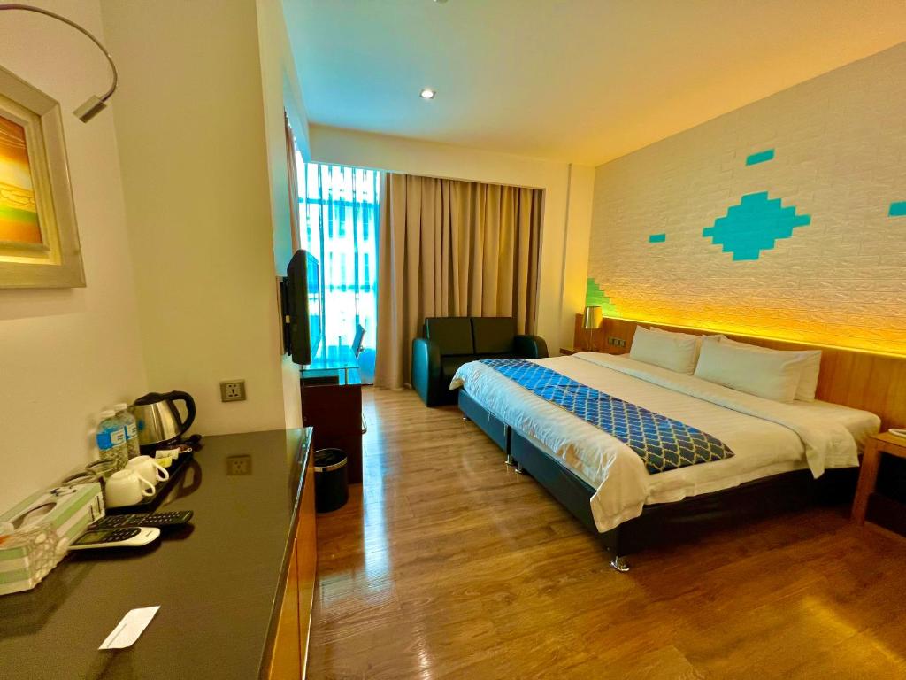 um quarto de hotel com uma cama e uma secretária em New World Express Motel em Bintulu