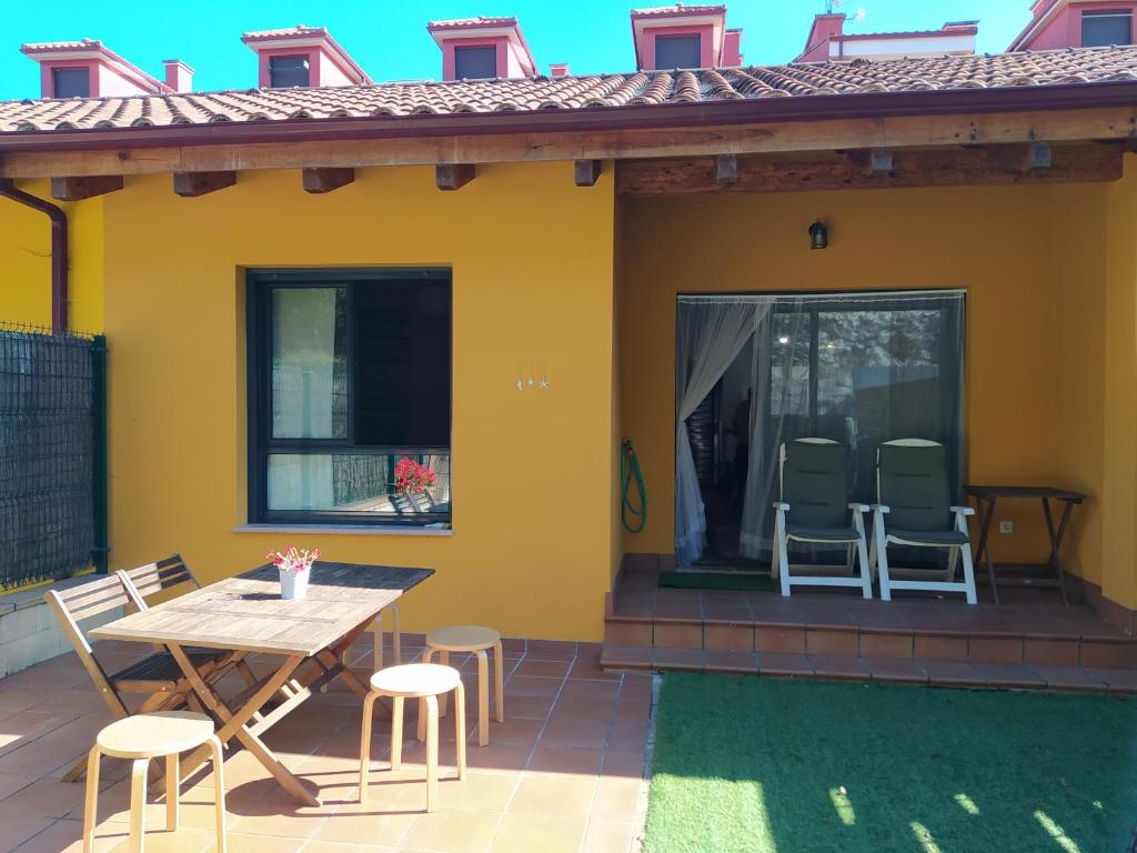une terrasse avec une table et des chaises dans une maison dans l'établissement Adosado de María - Para 4 pax en Posada de Llanes, à Llanes