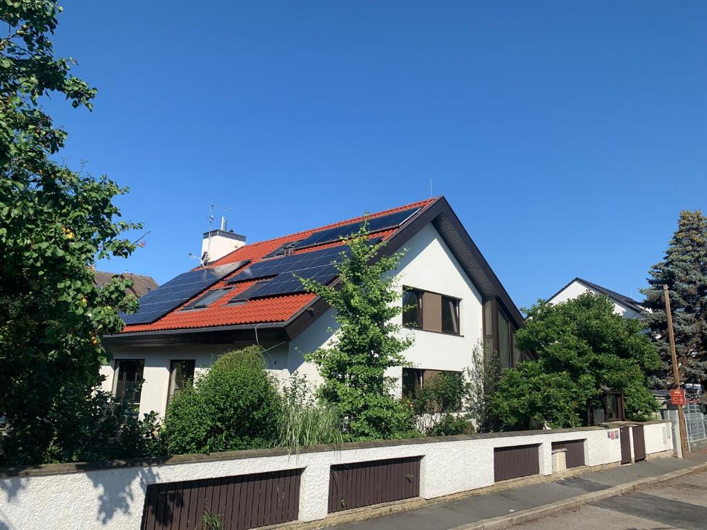 a house with a red roof and a fence at A. V. Pension Praha in Prague