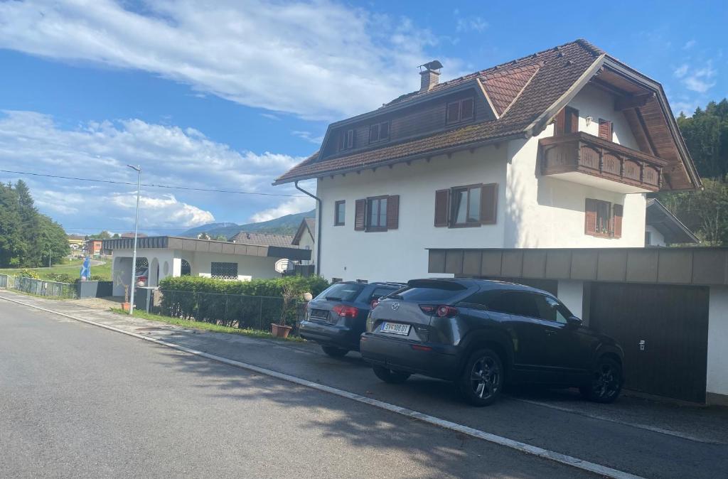 two cars parked in front of a house at Apartment 2 Feistriz in Rosental 9181 in Feistritz im Rosental