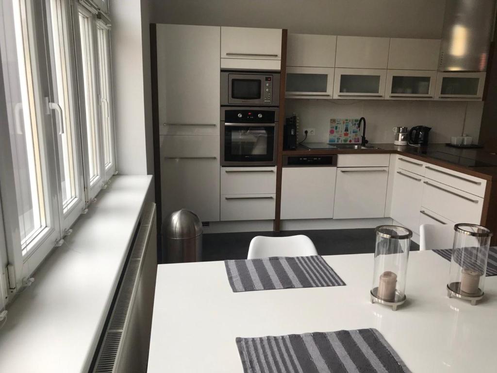uma cozinha com armários brancos e um balcão branco em Apartment Zebra em Viena