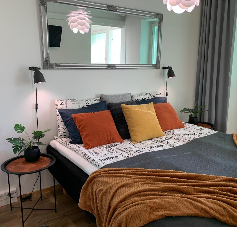 um quarto com uma cama com almofadas coloridas e um espelho em StarHomes Double lux 8 em Oulu
