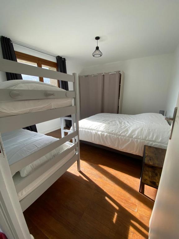 a bedroom with two bunk beds and a lamp at Appartement Le Lauzet in La Roche-de-Rame