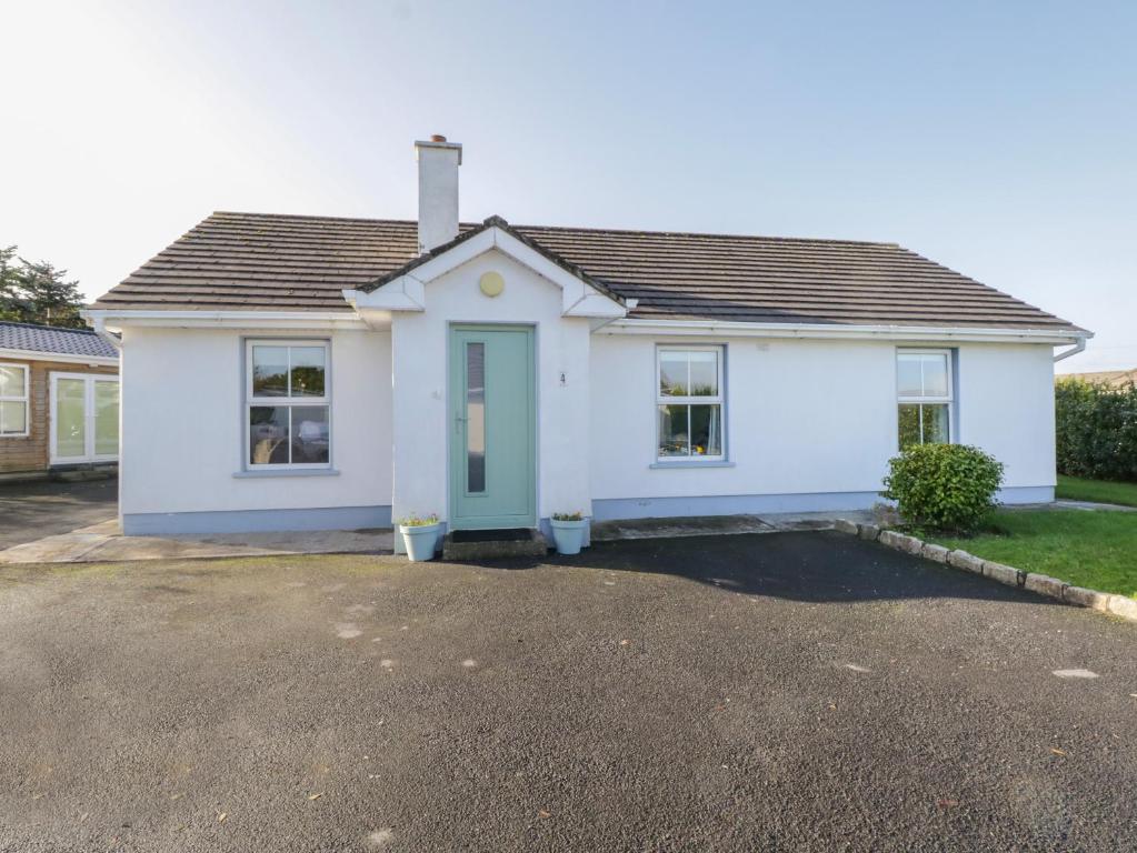 a white house with a driveway in front of it at Teach Teolai in Carraroe