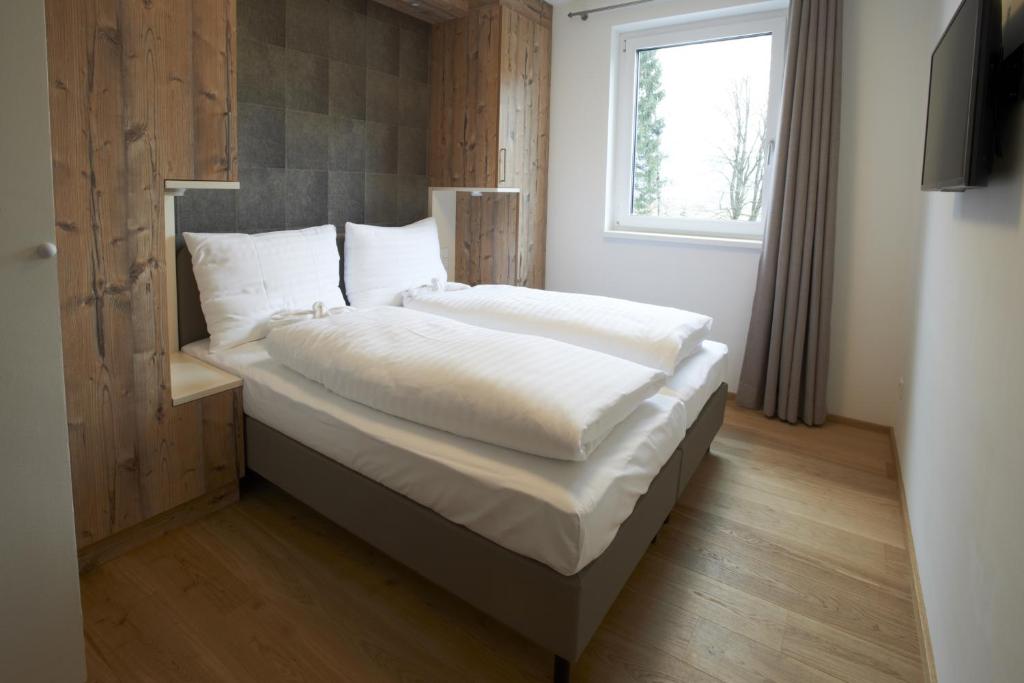 A bed or beds in a room at Ski & Golf Suites Zell am See by Alpin Rentals - incl Summercard