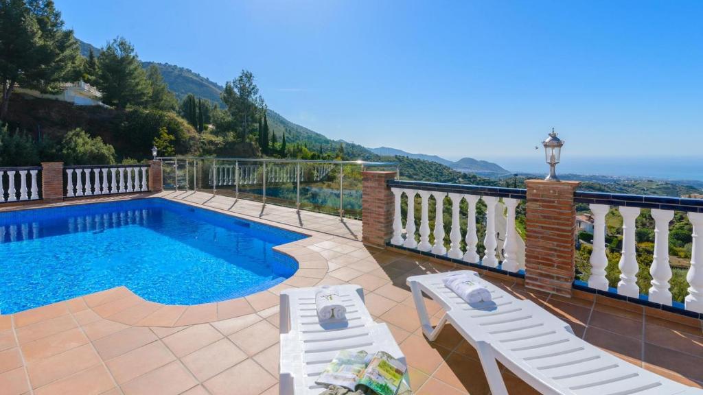una piscina con 2 sillas en el balcón en Villa el Pedregal Frigiliana by Ruralidays, en Frigiliana