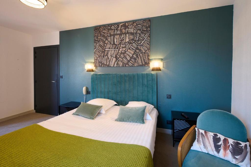 a bedroom with a bed and a painting on the wall at The Originals Boutique, Hôtel La Colonne de Bronze, Saint-Valéry-sur-Somme (Inter-Hotel) in Saint-Valery-sur-Somme