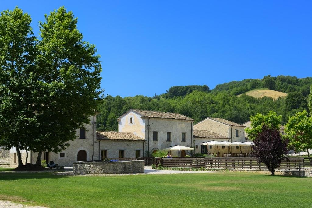 um grupo de edifícios com árvores e um campo de relva em Albergo Diffuso La Piana dei Mulini em Colledanchise