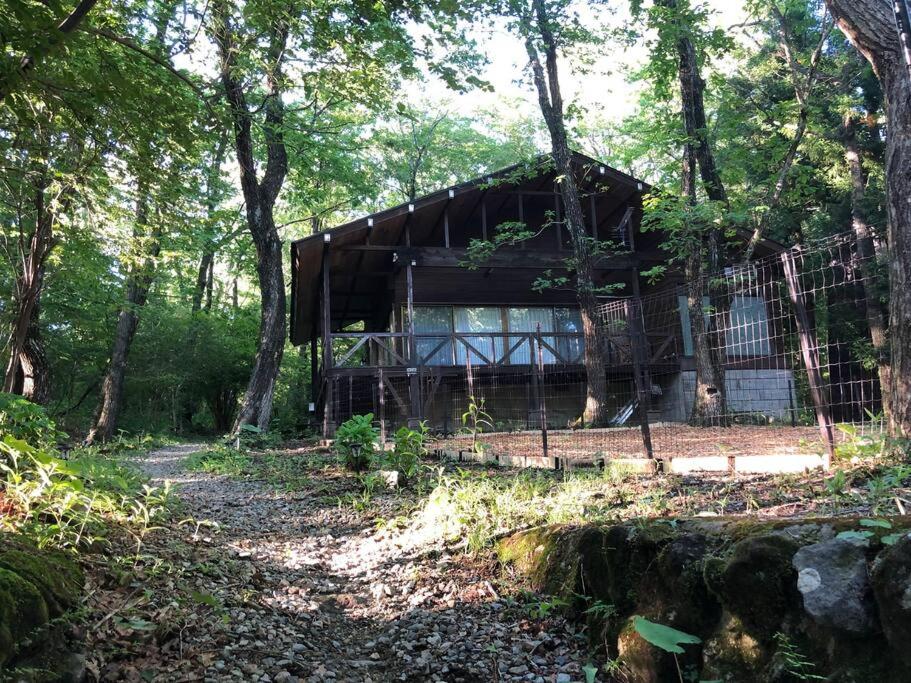 那須町湯本の那須御用邸近くのログハウス في Nasu-yumoto: منزل في وسط غابة