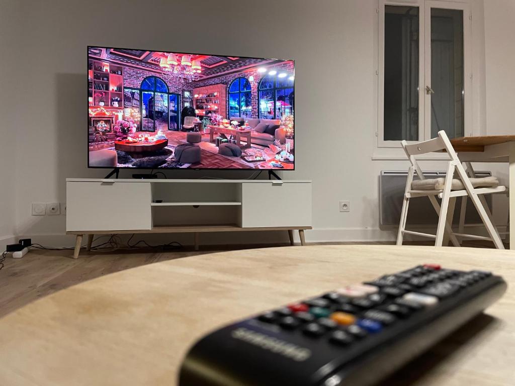 Televízia a/alebo spoločenská miestnosť v ubytovaní Les appartements d’Edgar