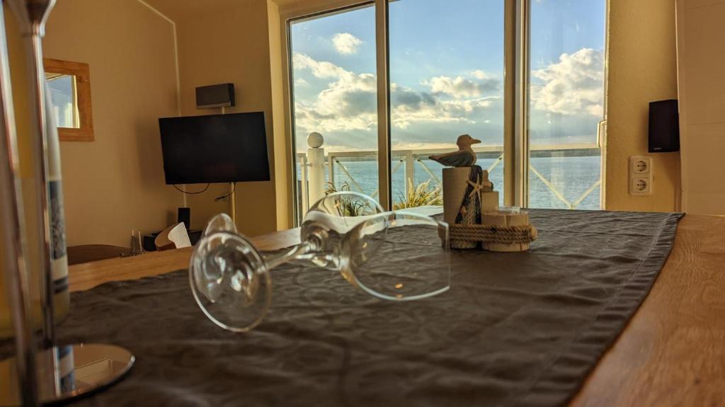 um quarto com uma mesa com copos de vinho em Strandkoje in erster Reihe mit traumhaftem Blick auf die Kieler Förde em Laboe