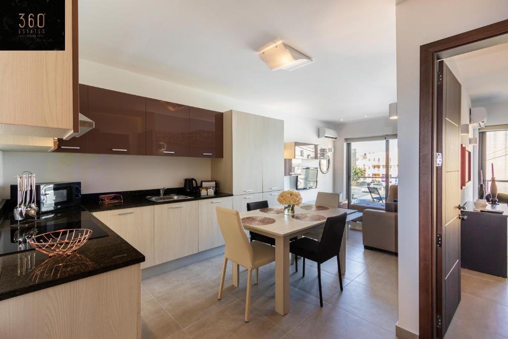 een keuken en eetkamer met een tafel en stoelen bij High-End central APT with comfy BED & Super WIFI by 360 Estates in San Ġwann