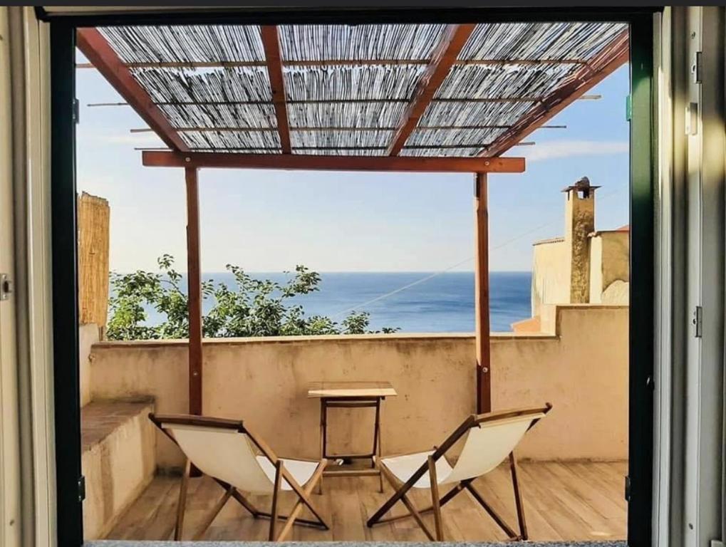 un patio con 2 sedie e un tavolo sul balcone di Au Giardin a Varigotti